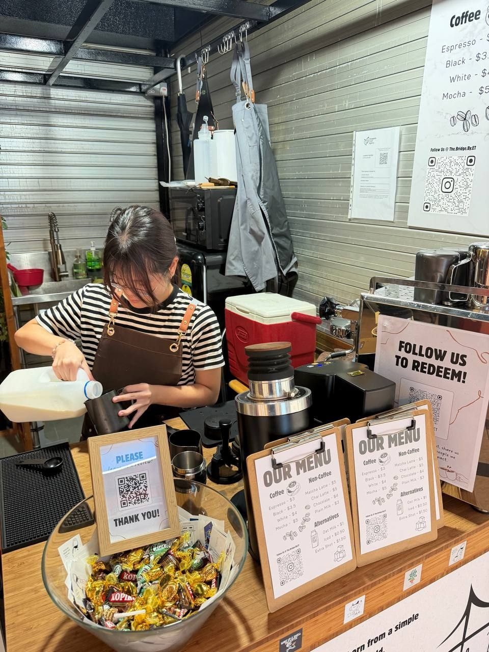Steaming milk behind the counter at The Bridge